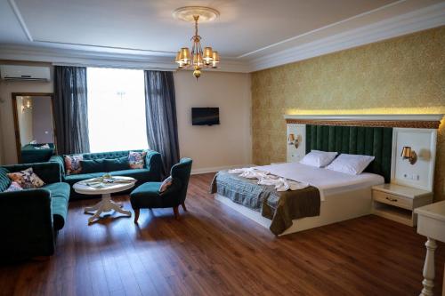 Habitación de hotel con cama y sala de estar. en Nafron Hotel en Prizren