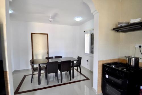 a dining room with a table and chairs and a mirror at Rosa Parks Villa - Sanyang The Gambia in How Ba