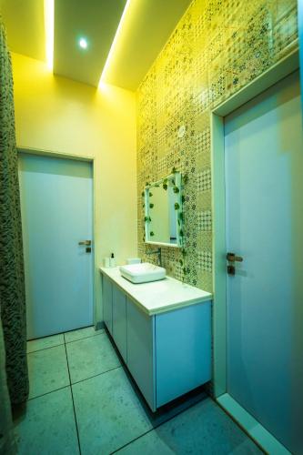 a bathroom with a white sink and a mirror at Spicy Mango Villa Gardena - Luxurious Villa In Karjat in Thākurvādi