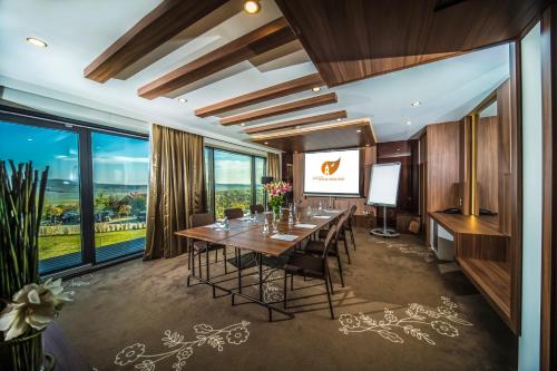 a conference room with a table with chairs and a projection screen at Castellum Hotel Hollókő in Hollókő