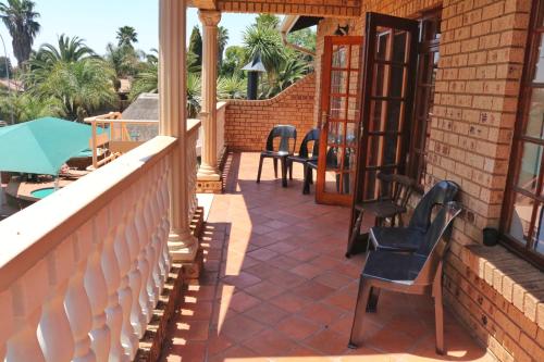 a balcony with chairs and tables on a house at Kairos Home in Middelburg
