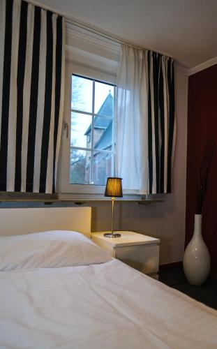a bedroom with a white bed and a window at Hotel-Restaurant Zur Mühle in Schermbeck