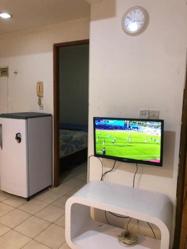 ein Wohnzimmer mit einem TV an der Wand in der Unterkunft Promo Mediterania Palace Kemayoran in Jakarta