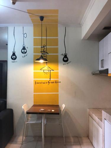 a dining room with a table and a yellow and white wall at Promo Mediterania Palace Kemayoran in Jakarta