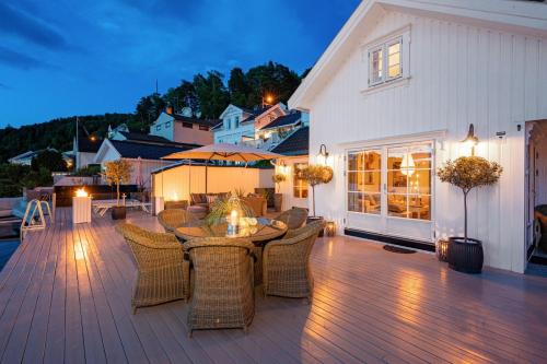 a patio with a table and chairs on a deck at Luxurious Boathouse with Private Dock in the Best Location in Arendal in Arendal
