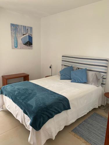 a bedroom with a large white bed with blue pillows at Perfect Summer in Cabanas de Tavira