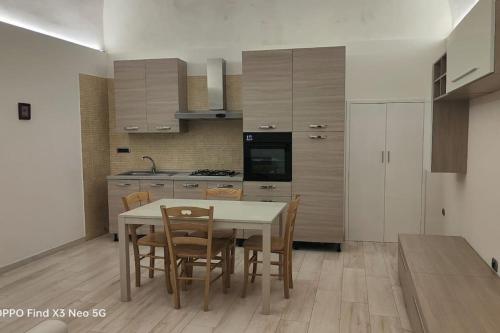 a kitchen with a table and chairs in a room at Pompei Priscus I Casa Vacanza in Scafati