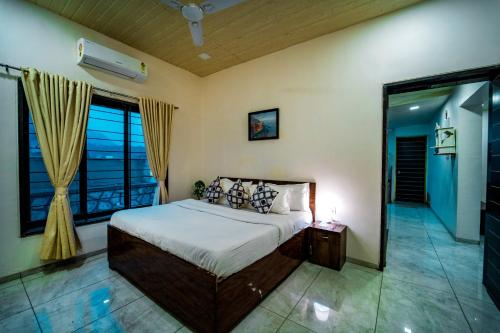 a bedroom with a bed and a large window at Spicy Mango Villa Insam - Hill View Villa In Karjat in Karjat
