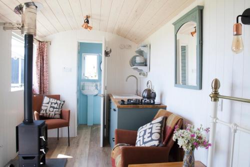 una cucina e un soggiorno in una casetta minuscola di Ewe With A View Sea View Shepherds Huts a Breage
