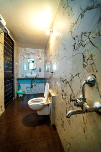 a bathroom with a toilet and a sink at Spicy Mango Villa Insam - Hill View Villa In Karjat in Karjat