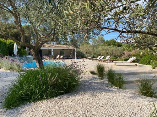 a swimming pool with a tree and a house at Charming, chic, secluded villa within walking distance from Lorgues in Lorgues