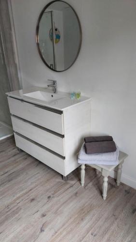 La salle de bains est pourvue d'un lavabo blanc et d'un miroir. dans l'établissement Aux trois petits cochons, à Hotton
