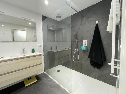 uma casa de banho com um chuveiro, um lavatório e um espelho. em Amplio y moderno piso de 4 habitaciones y terraza em Pontevedra
