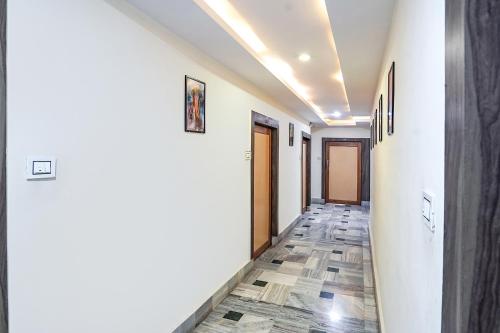 a hallway with white walls and a tile floor at FabHotel New Shanti in Allahābād