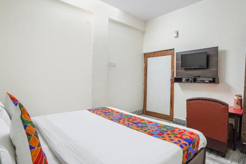 a hotel room with a bed and a tv at FabHotel New Shanti in Allahābād