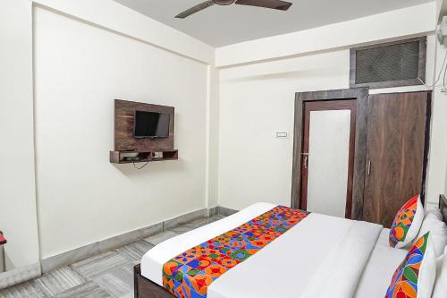 a bedroom with a bed and a tv on the wall at FabHotel New Shanti in Allahābād