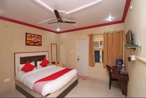 a bedroom with a bed with red pillows and a desk at OYO Mayur Guest House in Jīnd