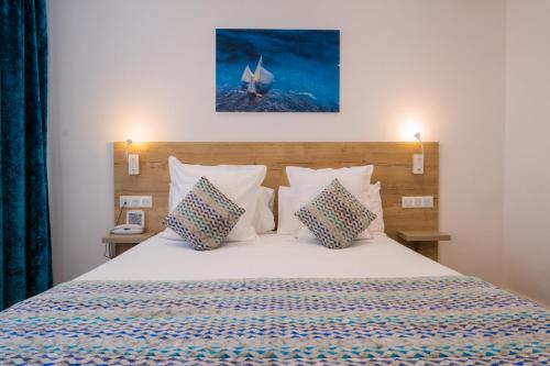 1 dormitorio con 1 cama con 2 almohadas y 1 barco en Hôtel de la Fontaine, en Niza