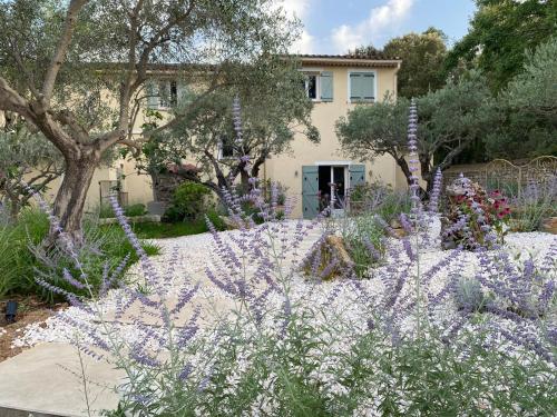 a garden with purple flowers in front of a house at Charming, chic, secluded villa within walking distance from Lorgues in Lorgues