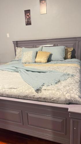 a bed with a wooden headboard and pillows on it at Odyssey Suites in Georgetown