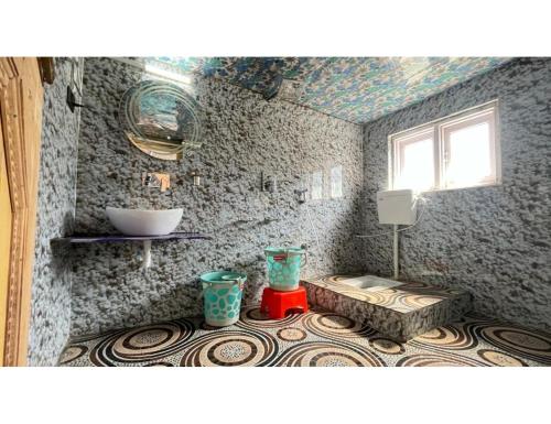 a bathroom with a sink and a table in a room at Travellers Homestay, Pahalgam in Pahalgām