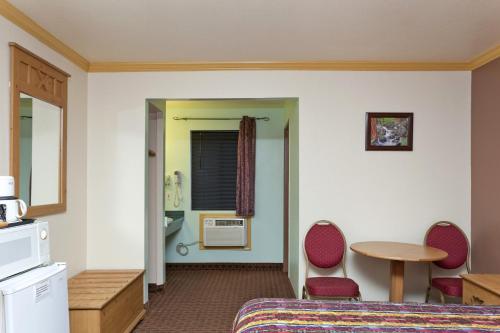 a hotel room with a bed and a table and chairs at National 9 Inn - Placerville in Placerville