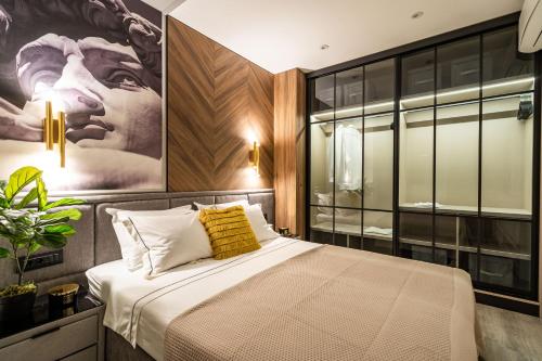 a bedroom with a large bed with a painting on the wall at Lux Kalifa 5 Star Exquisite Residence in Dubrovnik