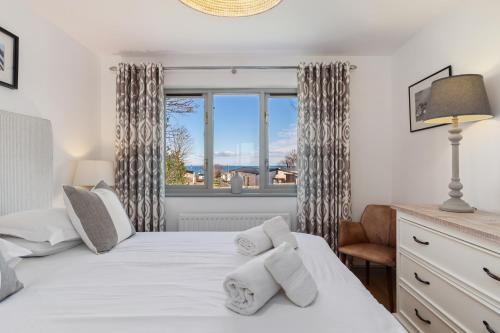 Un dormitorio con una cama con toallas blancas. en Oaktree Lodge - Luxury Cottage, Hot Tub, Sea Views, en Saundersfoot
