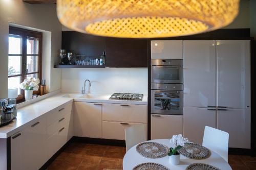 a kitchen with a table and a large chandelier at Toscana Amore Mio, stunning view & 14min Volterra in Montecatini Val di Cecina