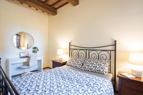 a bedroom with a bed and a desk and a mirror at Toscana Amore Mio, stunning view & 14min Volterra in Montecatini Val di Cecina
