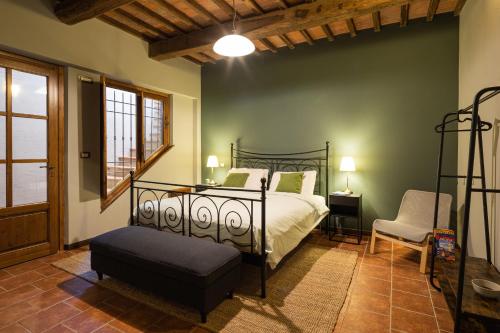 um quarto com uma cama e uma cadeira em Toscana Amore Mio, stunning view & 14min Volterra em Montecatini Val di Cecina
