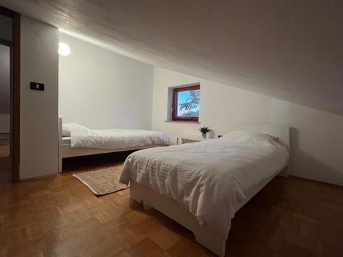 Piko's apartments في إيزولا: غرفة نوم بيضاء بسريرين ونافذة
