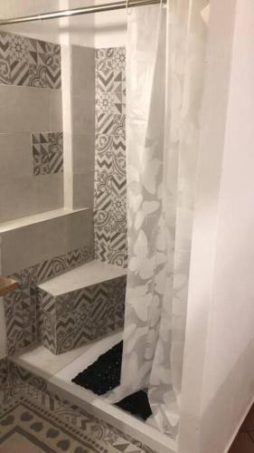 y baño con ducha con cortina blanca. en Camera Privata Orchidea en Castellero