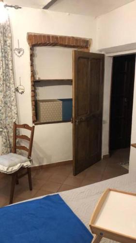 um quarto com uma cama, uma cadeira e um armário em Camera Privata Orchidea em Castellero