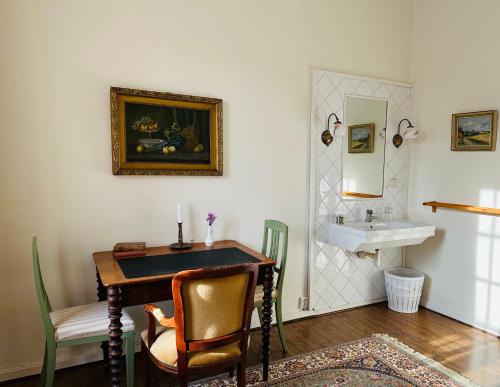 a bathroom with a table and a sink in a room at Köpmansgården Bed & Breakfast in Vellinge