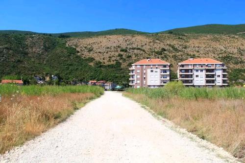 a dirt road with two apartment buildings in the distance at Aurora Apartments in Igalo