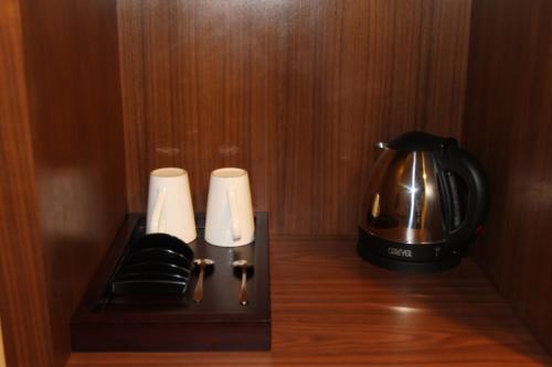a coffeemaker and coffee pot on a wooden holder at I Hotel Baloi Batam in Nagoya