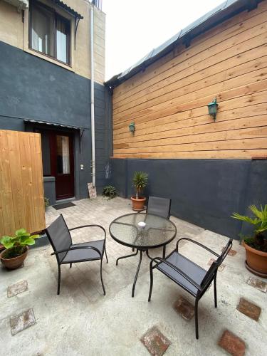 a patio with a table and chairs and a fence at Terrace House Near Opera in Tbilisi City