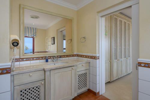 y baño con lavabo y espejo. en San Lameer Villa 13934- 4 Bedroom Deluxe - 8 pax- San Lameer Rental Agency, en Southbroom