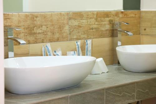 a bathroom with two white sinks on a counter at Ttdropin Homestay in Taitung City