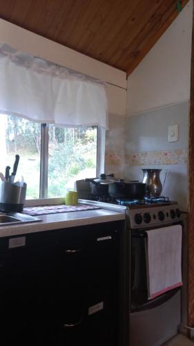 a kitchen with a stove and some pots and pans at Espectacular cabaña campestre con granja in Zipaquirá