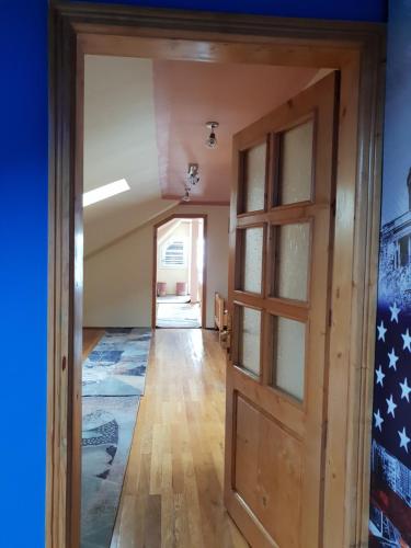 a hallway with a door and a flag on the wall at Antal Apartmans Lunca de Sus Kulcsosház Gyimesfelsőlok in Lunca de Sus