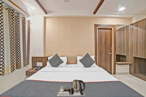 a hotel room with a bed and a telephone at Townhouse Tulip in Vadodara