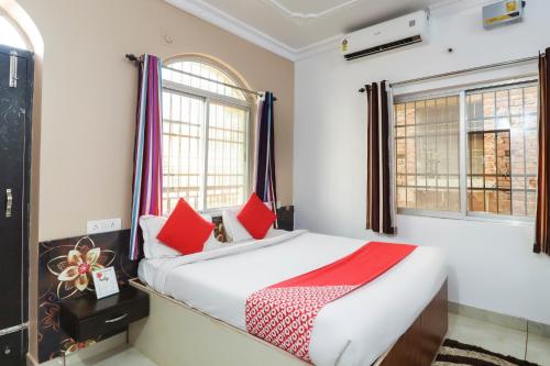een slaapkamer met een bed met rode kussens bij Super Capital O Hotel The Tulip in Rānchī
