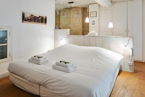 ein weißes Bett mit zwei Handtüchern darüber in der Unterkunft Large atypical flat at the heart of Montpellier - Welkeys in Montpellier