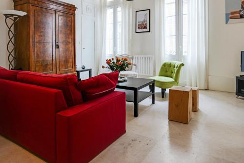 salon z czerwoną kanapą i stołem w obiekcie Appartement Teissiers - atypique - Welkeys w Montpellier