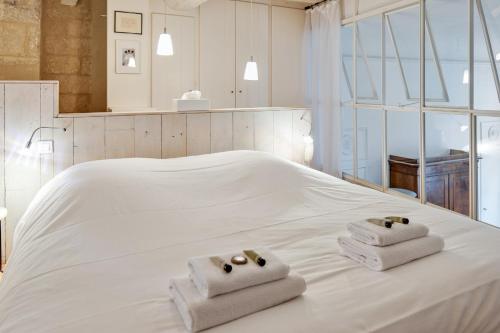 - un lit blanc avec 2 serviettes pliées dans l'établissement Appartement Teissiers - atypique - Welkeys, à Montpellier