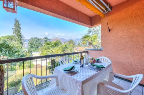 a white table and chairs on a balcony with a view at Residenza Borgo Rustico with Pool - Happy Rentals in Collina d'Oro