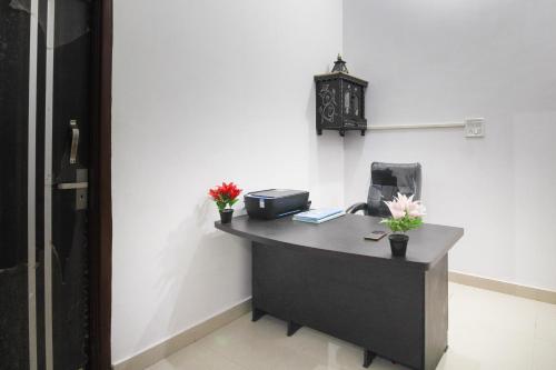 an office with a desk with a clock on the wall at SPOT ON Green Valley in Meerut