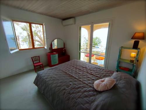 a bedroom with a large bed with a large window at Lilly's Seaview Retreat Cottage in Avlákia